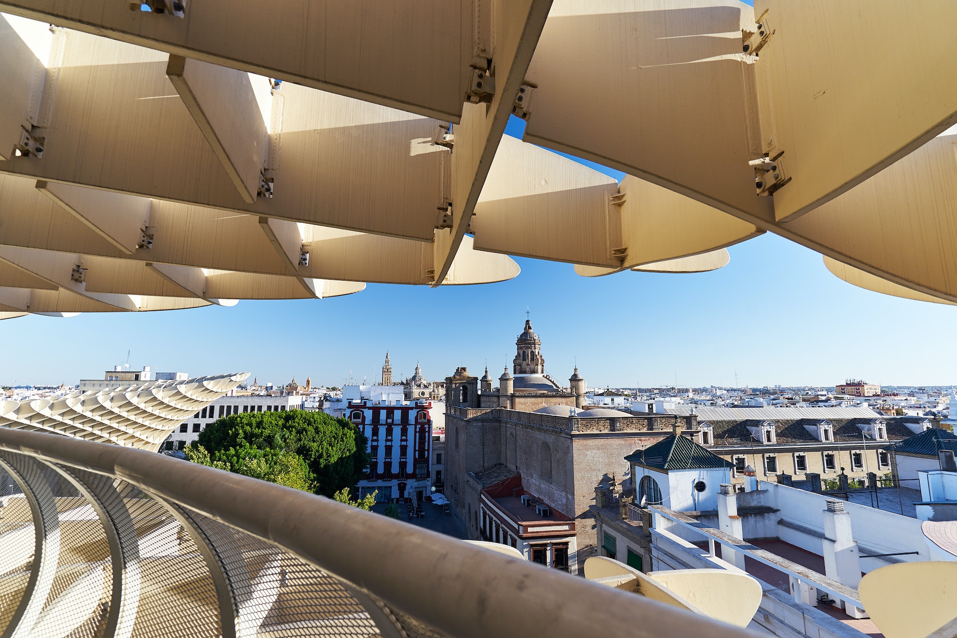 A wooden modern elevated walkway offering views over older city buildings