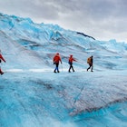 Four people walking on Mendenhall Glacier, Alaska, USA