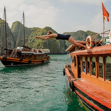 woman diving off of a boat in Halong Bay Vietnam