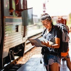 1053803902
horizontal image
A woman standing on a railway platform reading a map in Thailand