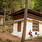 A Woman Outside Tiger's Nest Monastery in Paro, Bhutan Springtime
A young woman, wearing hiking gear, stands outside Tiger's Nest monastery, also known as Paro Taktsang, located 900m up on a cliffside in the valley town of Paro, Bhutan. Tiger's Nest monastery, constructed in 1692, was built around the cave where Guru Rinpoche first meditated. Shot on a bright spring afternoon.