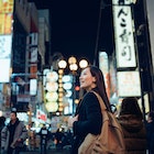 Smiling young Asian female traveller exploring and strolling along the busy and colourful neon signboard downtown city street at night in Osaka, Japan
1202888936