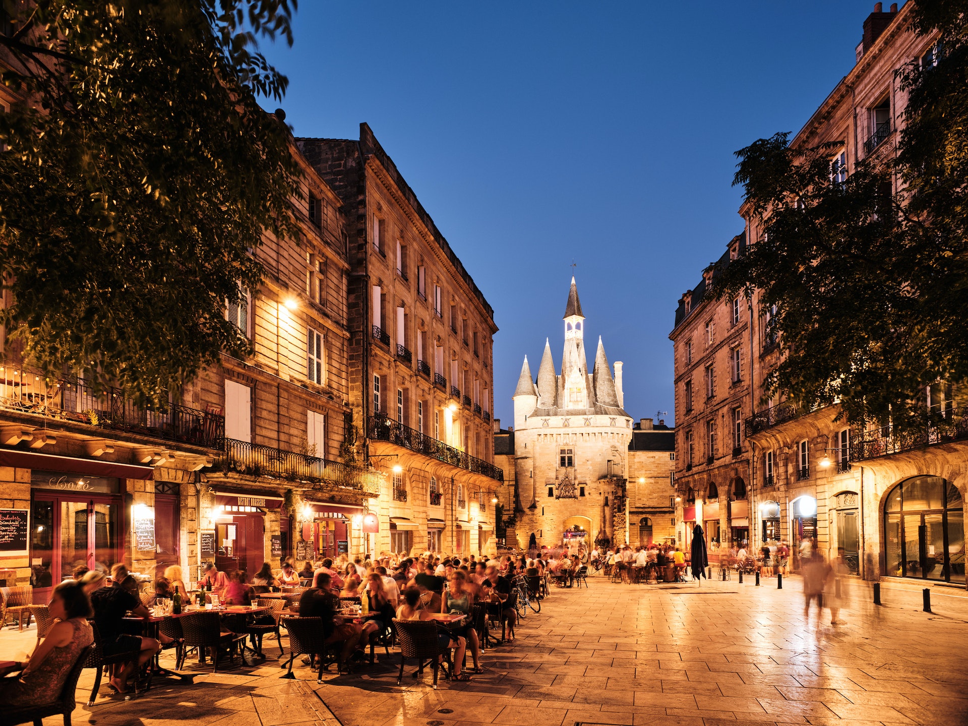 People sit outside cafes and bars on a hot summer's evening in a city 