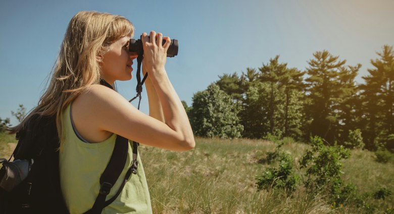 Young woman bird watching with binoculars at Indiana Dunes State Park.
1325470474