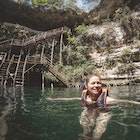 Smiling caucasian woman swimming in Cenote, wearing a life jacket.
1404763410