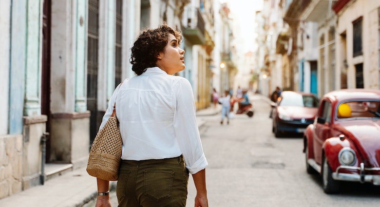 Cuban girl walking down street in Havana, exploring the city with curiosity
1456178960