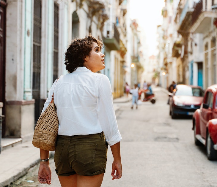 Cuban girl walking down street in Havana, exploring the city with curiosity
1456178960