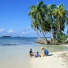 A mother and two kids playing on the beach in Belize