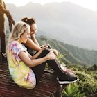 Two young women sitting on balcony overlooking Lake Atitlan, Guatemala