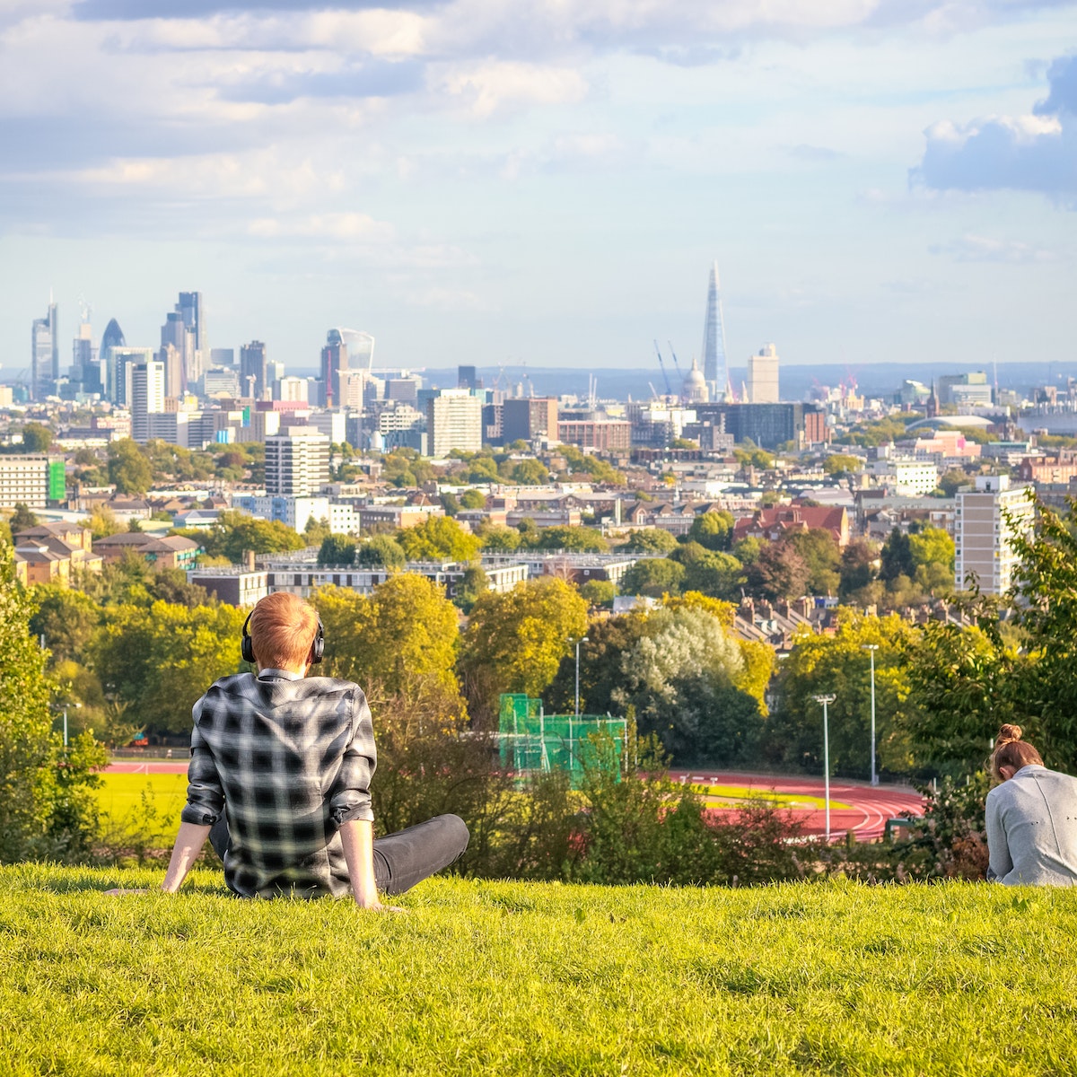 Visitors looking over London city skyline from Hampstead Heath.