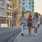 Young friends walking on sidewalk during sunset in Havana. Happy male and females are enjoying vacation. They are wearing casuals.
914846138