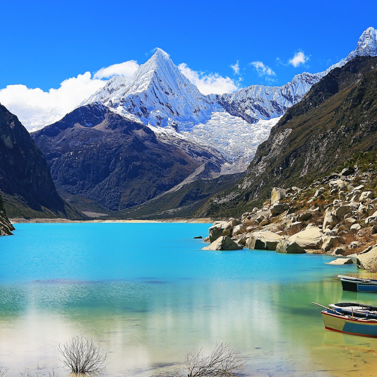 Wooden boats anchored on Paron lake in Cordillera Blanca.