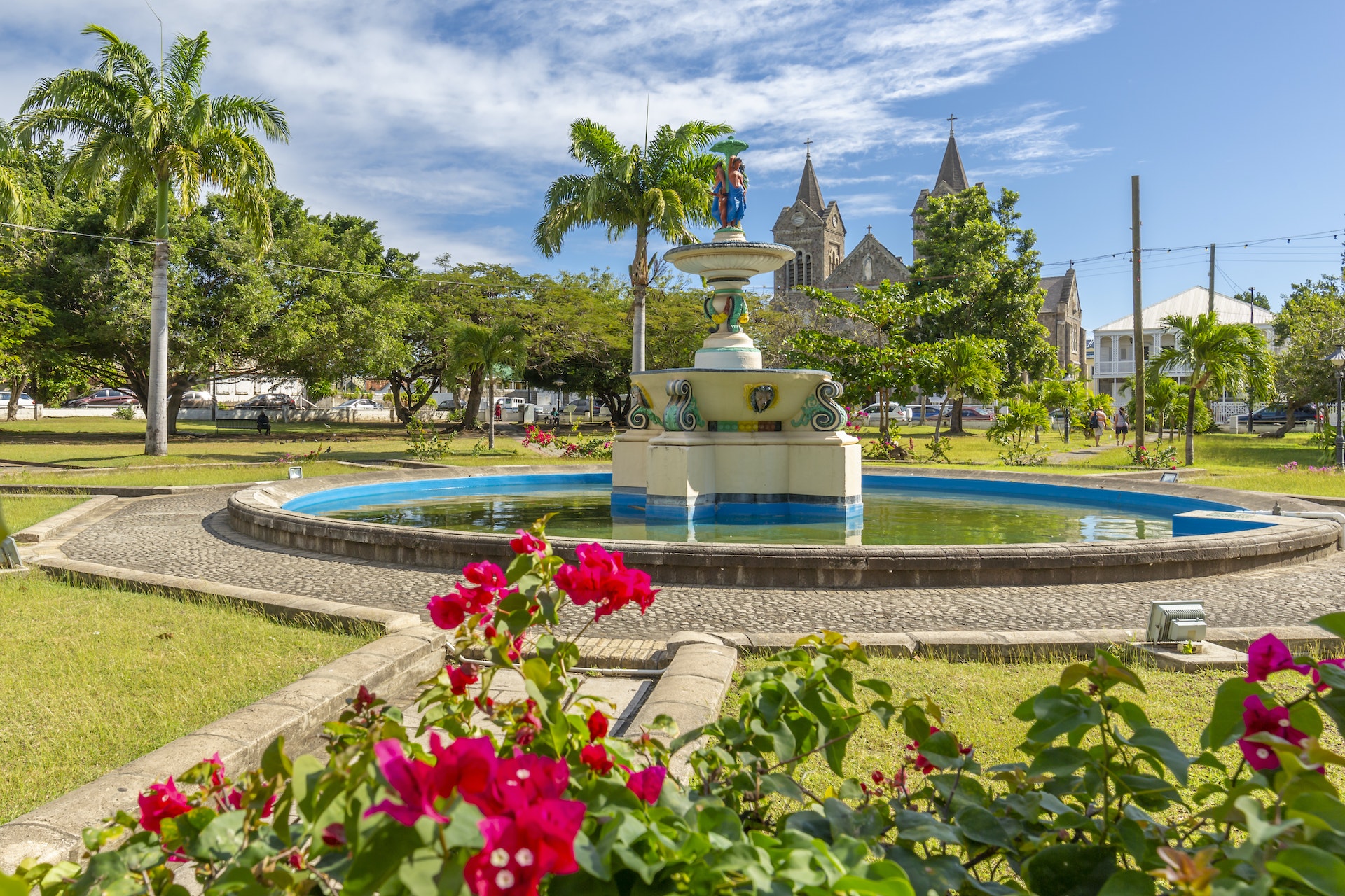 View of flowers and trees around the fountain at Independence Square and Immaculate Conception Catholic Co-Cathedral, Basseterre, St Kitts