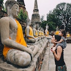 Ayutthaya, Buddha statues in a row in Wat Yai Chai Mongkhon, mother and daughter in front of a Buddha statue.