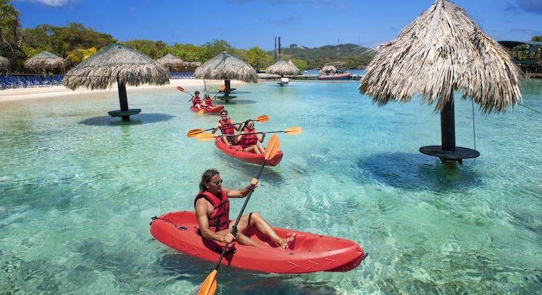 People kayaking near the beach in Roatan, Honduras