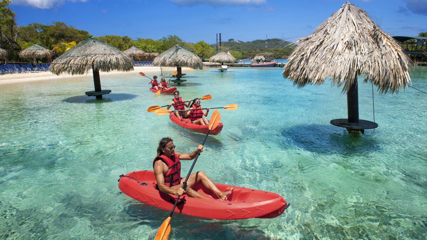 People kayaking near the beach in Roatan, Honduras