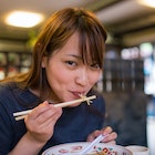 Young woman eating ramen noodle in old Japanese restaurant