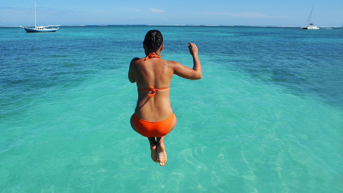 BELIZE - NOVEMBER 2016: A woman jumps off a dock and into the Caribbean Sea in San Pedro, Belize. ; Shutterstock ID 517065442; full: 65050; gl: Online Editorial; netsuite: Things to know Belize; your: Bailey Freeman
517065442