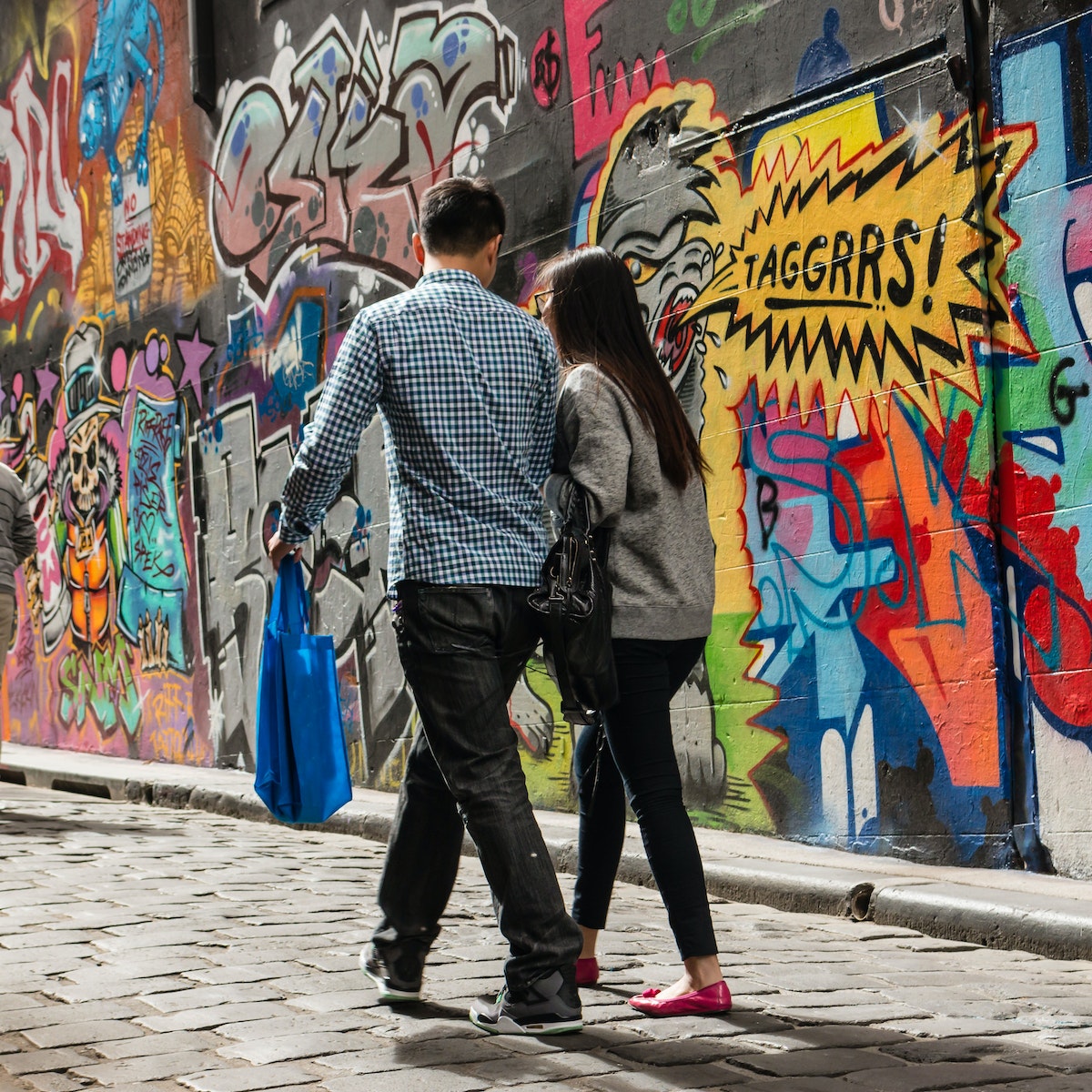 Melbourne, Australia - March 22, 2014: people walking past graffiti wall in Hosier Lane in Melbourne