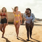 Happy multiracial females with different body size having fun walking on the beach during summer holidays