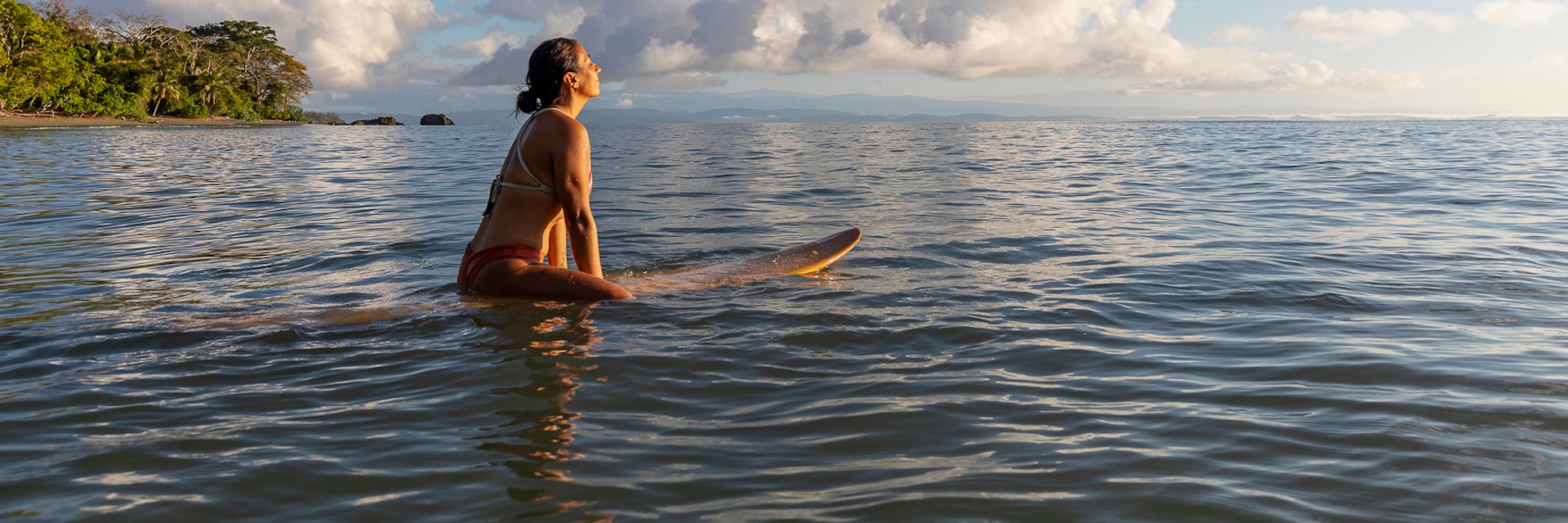 Stock Photo of Beautiful Hispanic female surfer in Costa Rica at sunrise