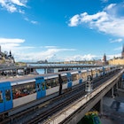 Panoramic view of the center of Stockholm. The metro train moving the Slussen district. Amazing view of the Sodermalm  island, The City Hall,  Riddarholmen in Gamla Stan. Text on road signs "Old Town"; Shutterstock ID 1722718684; your: Brian Healy; gl: 65