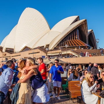 Friends hug in front of the Sydney Opera House © Isabella Moore/Lonely Planet